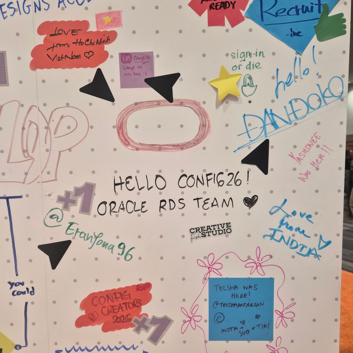 A Config 2026 guest wall covered in notes and doodles, including "Hello Config 26! Oracle RDS Team".